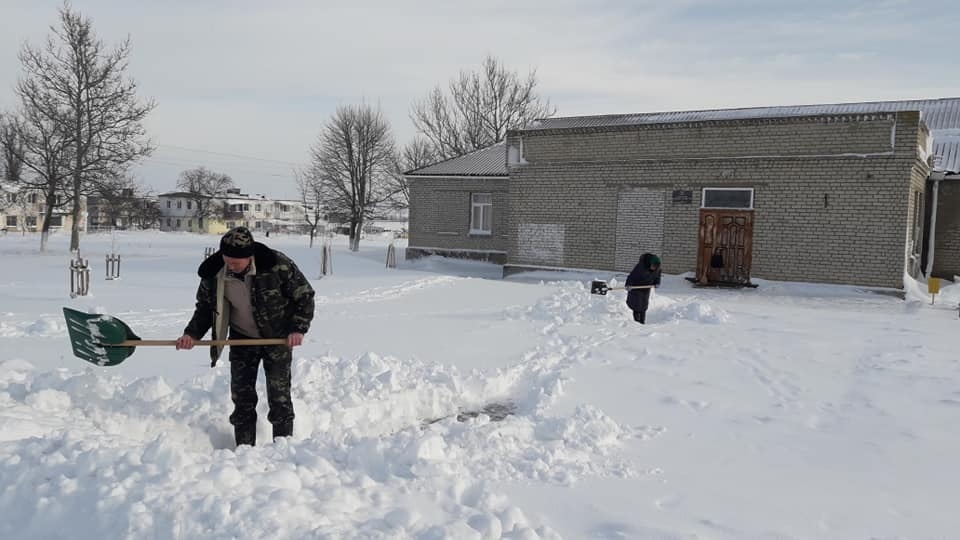 Працівники та працівниці Майорівського БК розчищають доріжки до закладу 