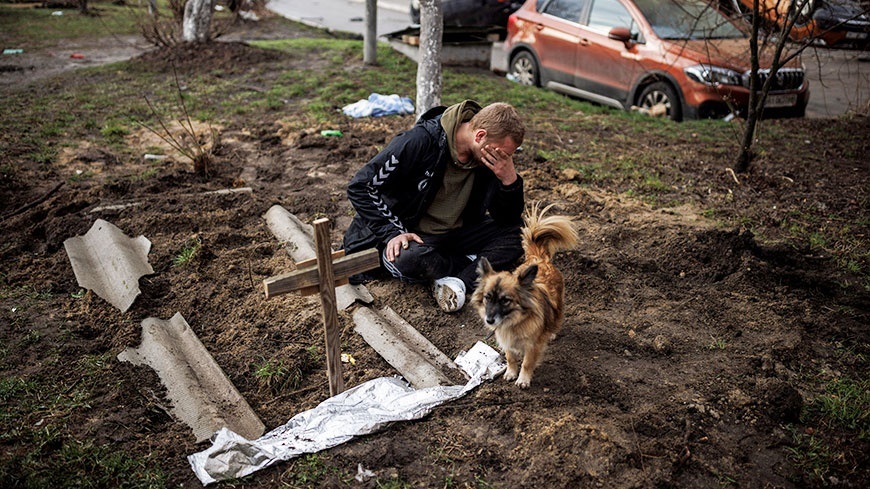 Чоловік плаче у траурі біля могили свого друга в Бучі, Україна. 6 квітня 2022 р. 