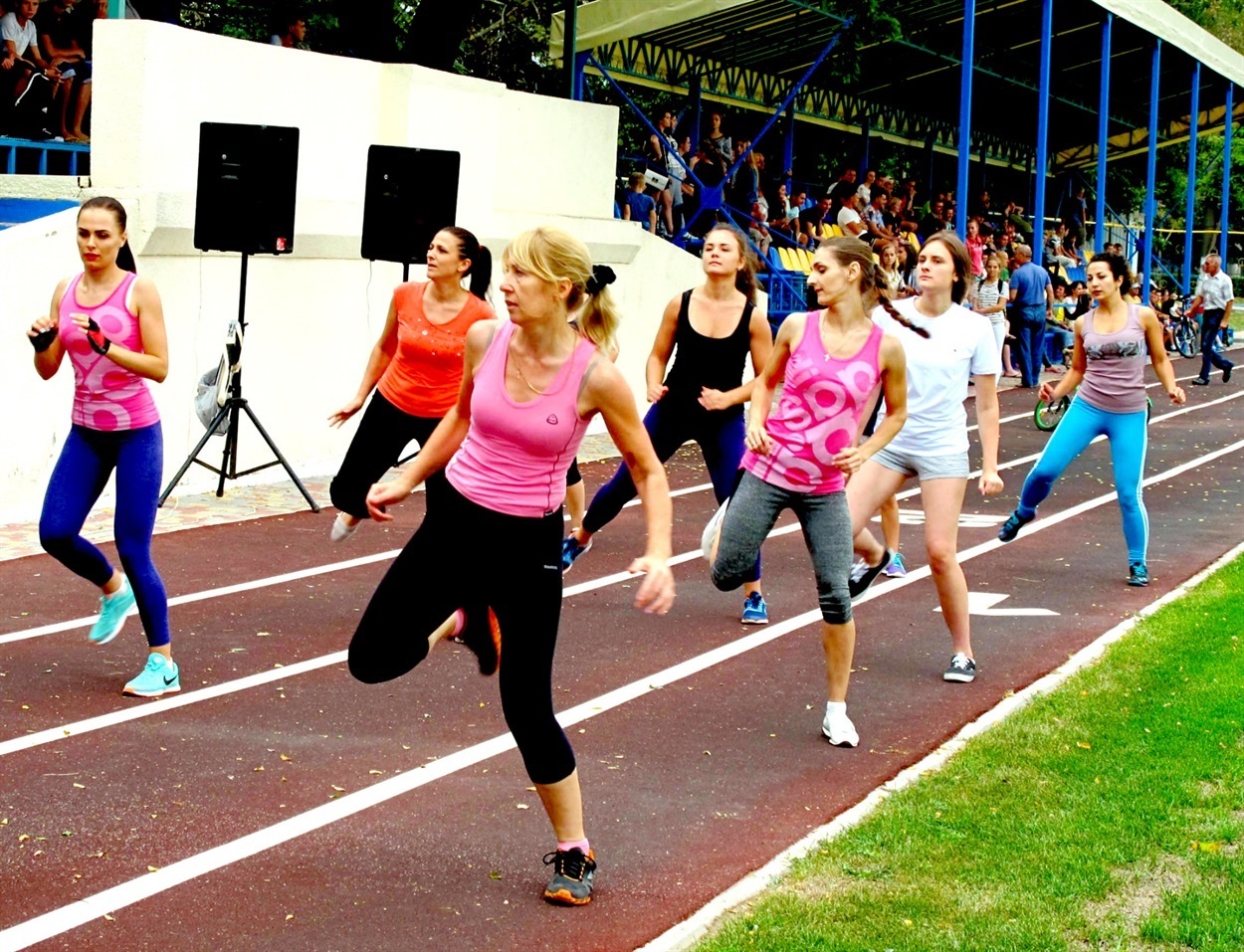 Дівчата та жінки з групи зайнять з фітнесу разом зі своїм інструктором Звягінцевою Наталією демонструють майстер-клас на стадіоні під час святкування Дня Незалежності
