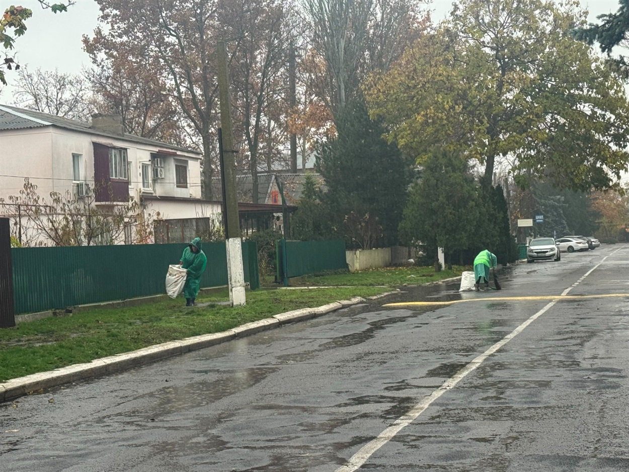 Біляївські комунальниці збирають сміття під час дощу